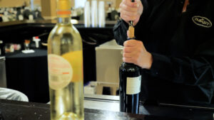 The Embassy bartender opening a bottle of wine