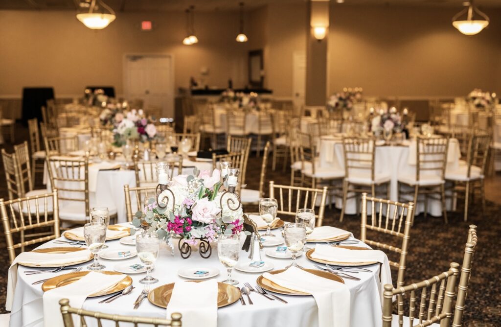 4 Tips to Minimize Last-Minute Event Changes 1 Wedding venue table set up - round tables with gold chairs, plates and water glasses